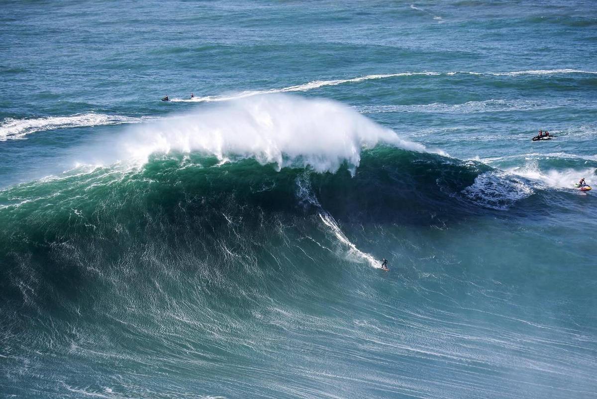 surfista a surfar na praia do norte, na nazaré