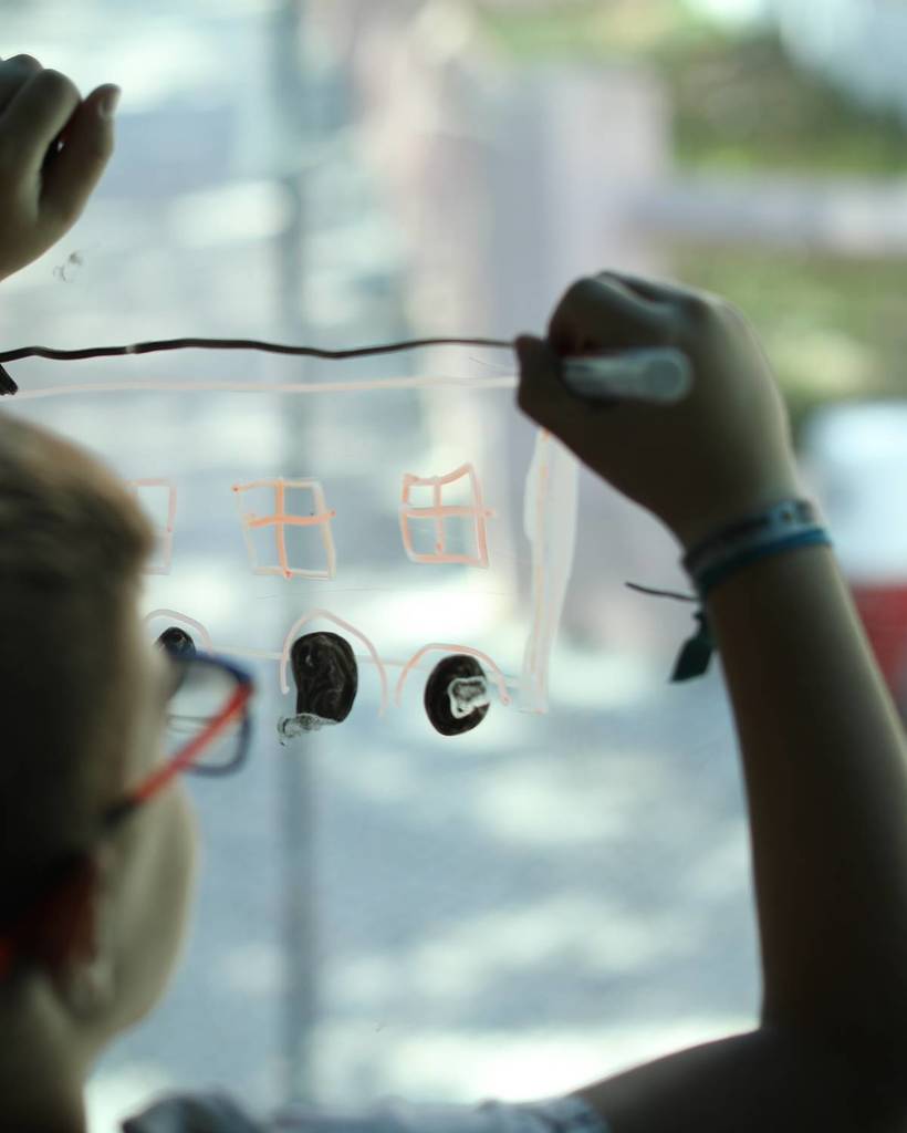 bambino che dipinge una finestra di un tram della Carris
