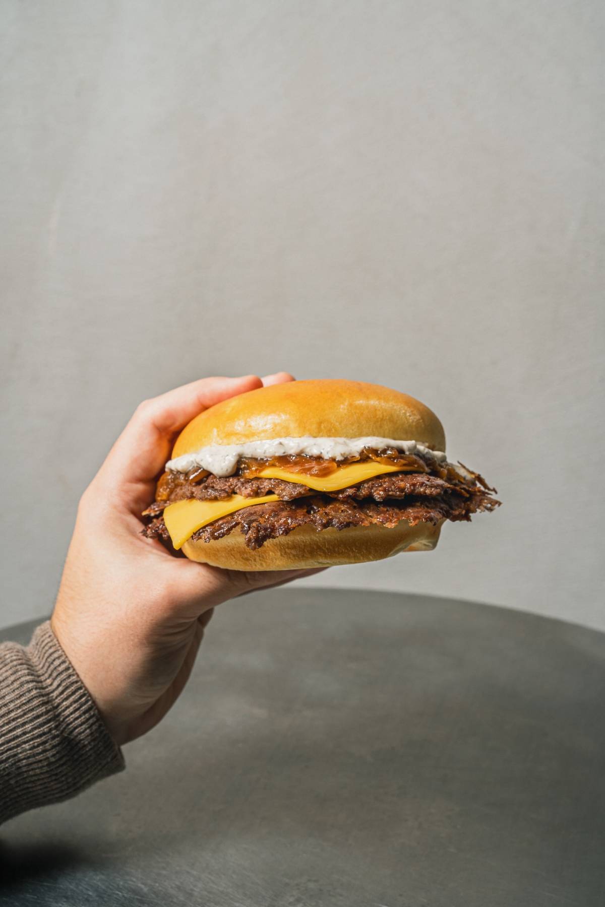 person holding Street's new smash burger, Street Truffle Burger