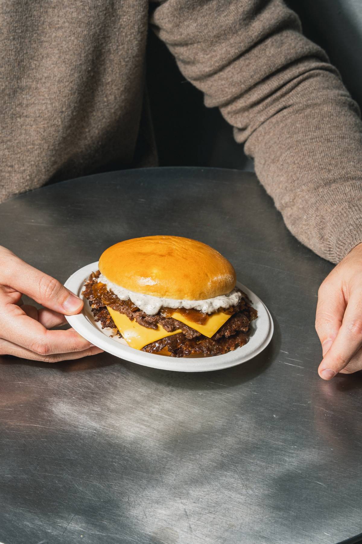 person holding Street's new smash burger, Street Truffle Burger