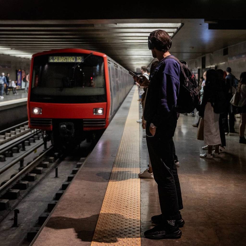 Hombre con mochila a la espalda esperando el metro en Lisboa.