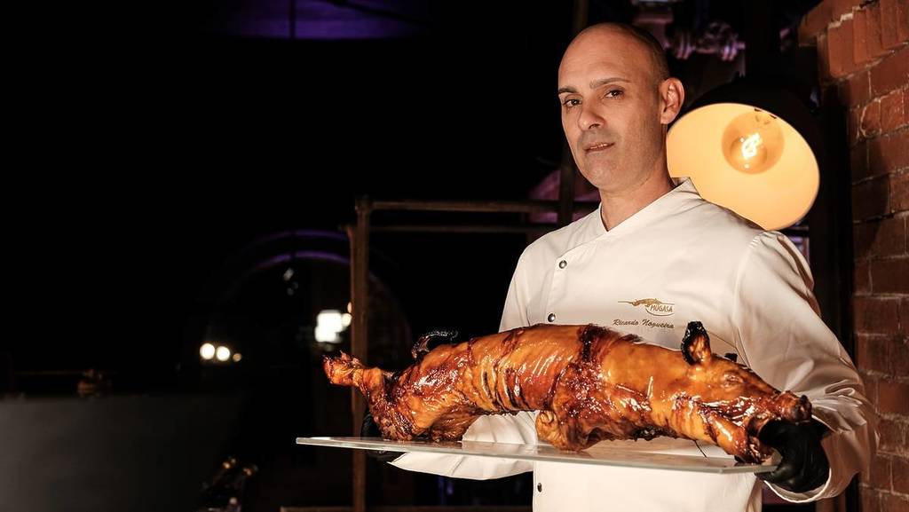 Chef Ricardo Nogueira com um Leitão à Bairrada nas mãos