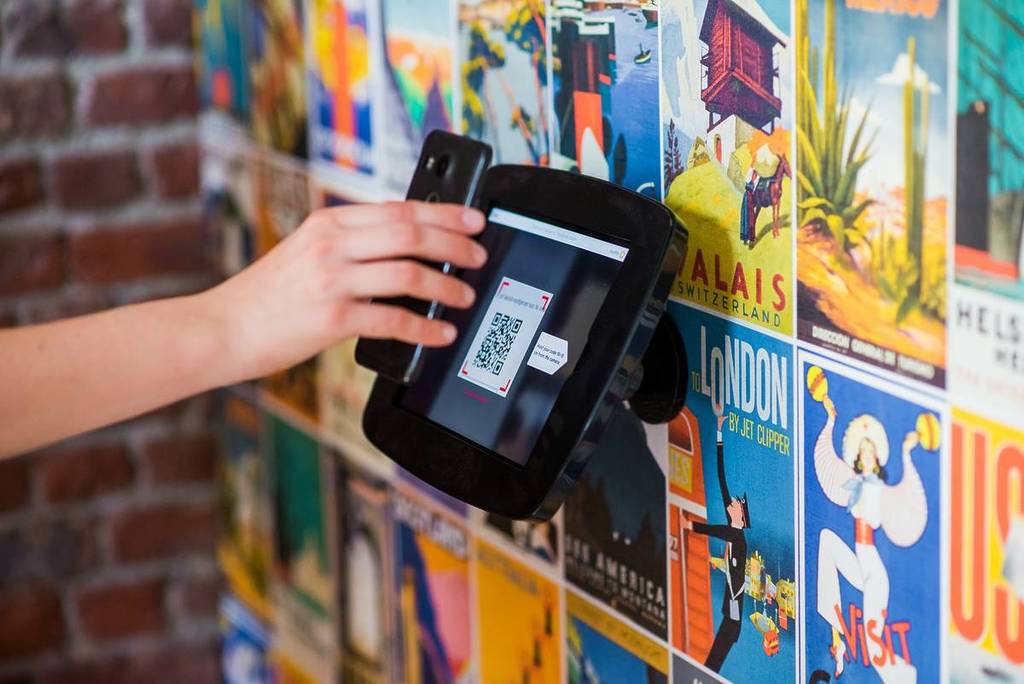 pessoa com telemóvel a scanear qr code 