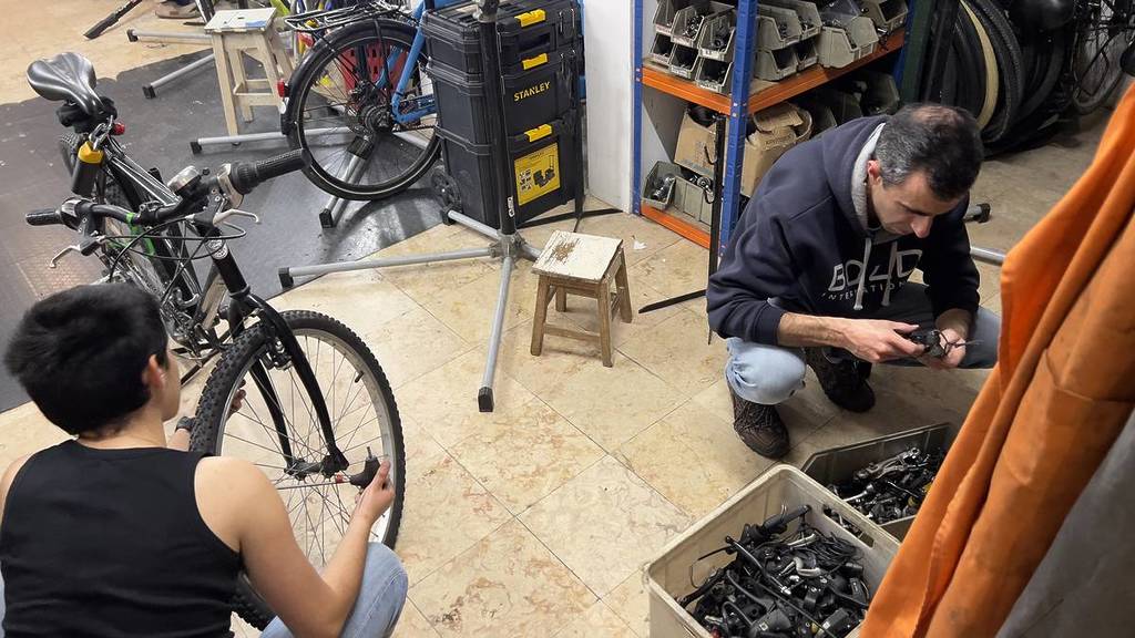 gente reparando bicicletas en la Cicloficina dos Anjos