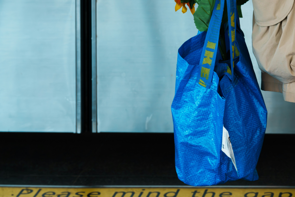 homem a carregar saco azul FRAKTA do ikea 