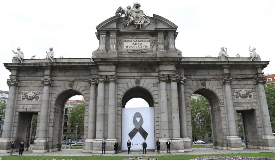 Un crespón negro cuelga de la Puerta de Alcalá en recuerdo de los fallecidos por Covid-19