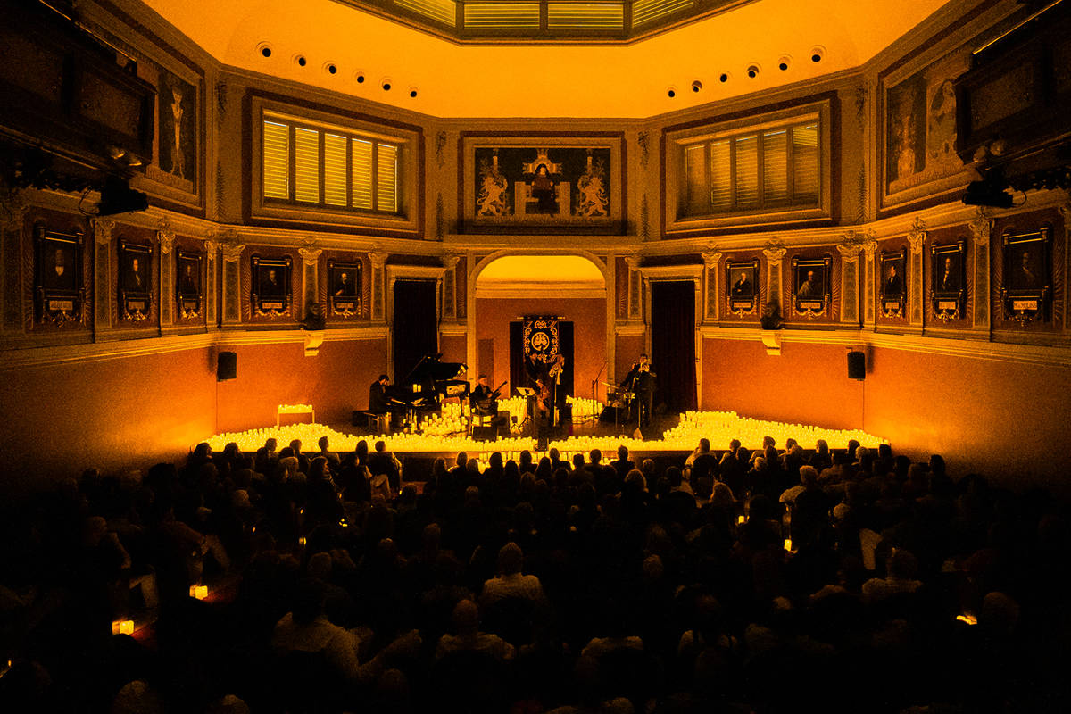 Banda tocando en el escenario del Ateneo de Madrid rodeada de velas