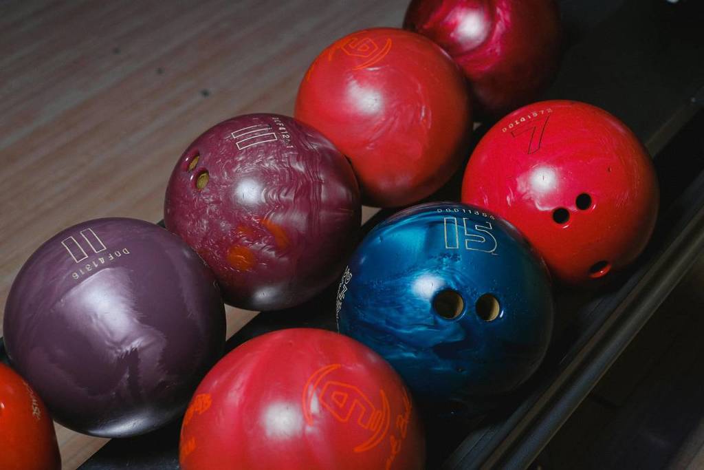 Siete bolas de bolos de diferentes colores en el carril