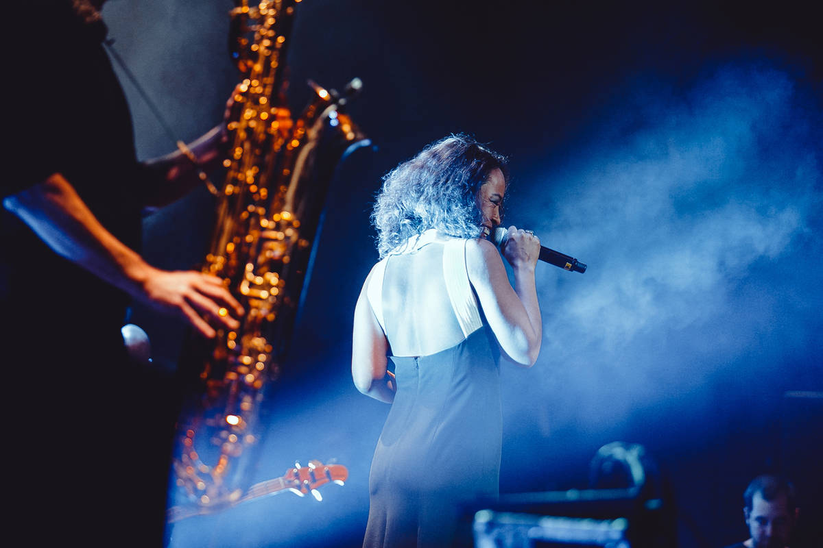 Vocalista de jazz bajo los focos del escenario y un saxofonista al lado