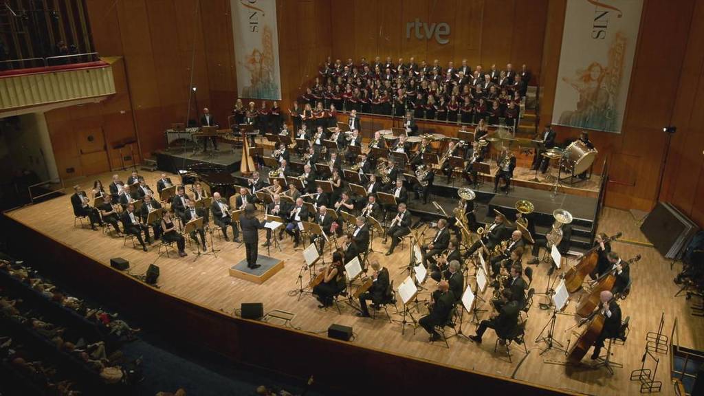 Panoramica dell'interno del Teatro Monumental durante un concerto con la Banda Sinfonica Municipale di Madrid, il Coro Talía, Celia Alcedo, Enrique Ferrer e Momo Cortés.