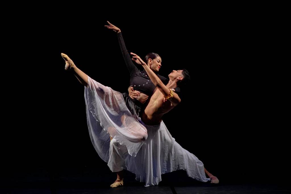 Um casal de dançarinos atua num palco dançando ballet.