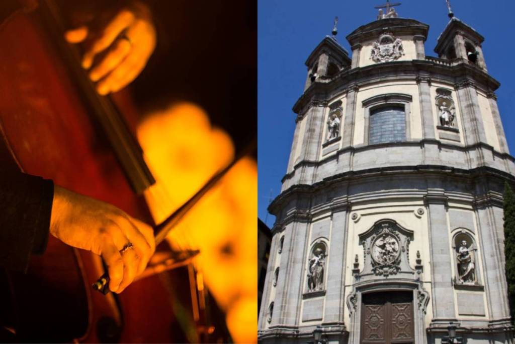 Primeiro plano das mãos de um músico a tocar violoncelo durante um concerto à luz das velas e a fachada da Basílica Pontifícia de São Miguel, em Madrid.