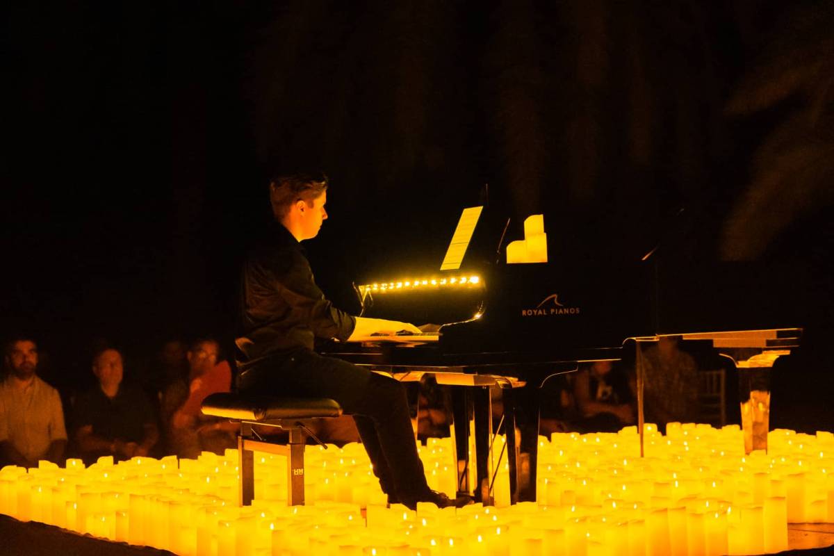 Un pianista toca sobre un escenario cubierto de velas durante un concierto Candlelight en Málaga.