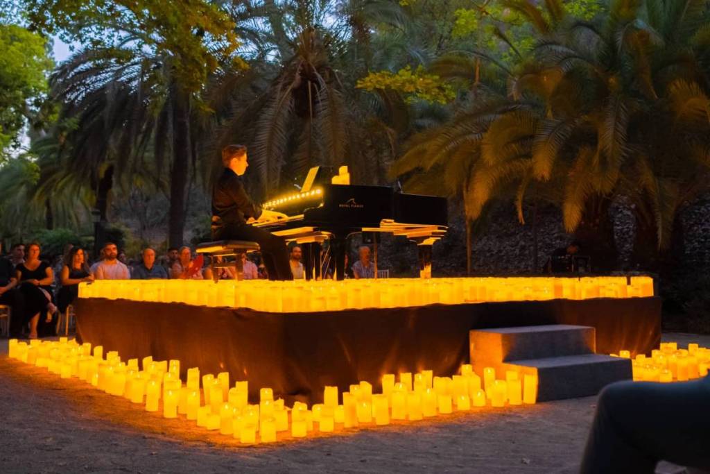 Un pianista toca sobre un escenario cubierto de velas durante un concierto Candlelight en Málaga.