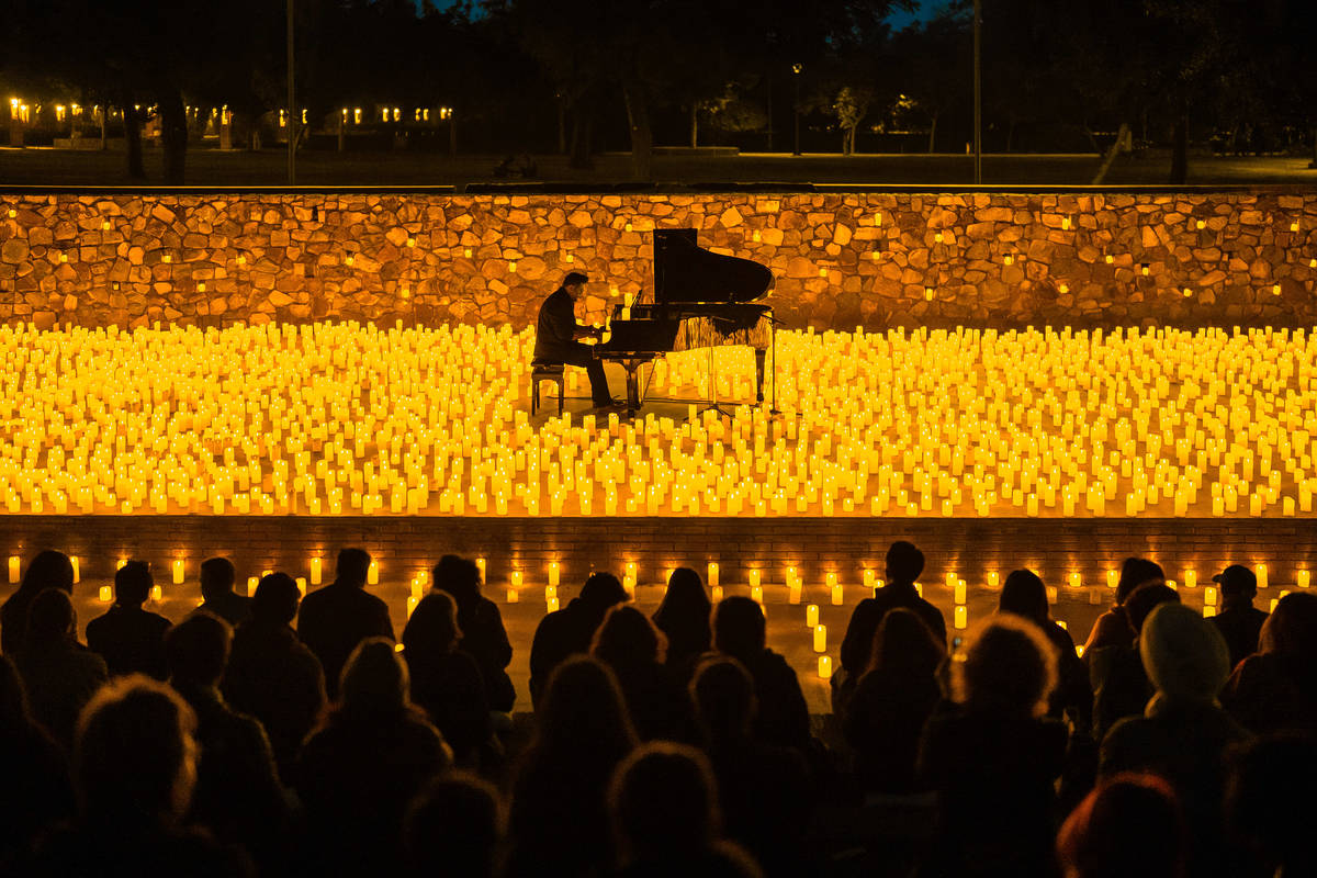 Plano general de una pianista sobre un escenario cubierto de velas durante un concierto Candlelight.
