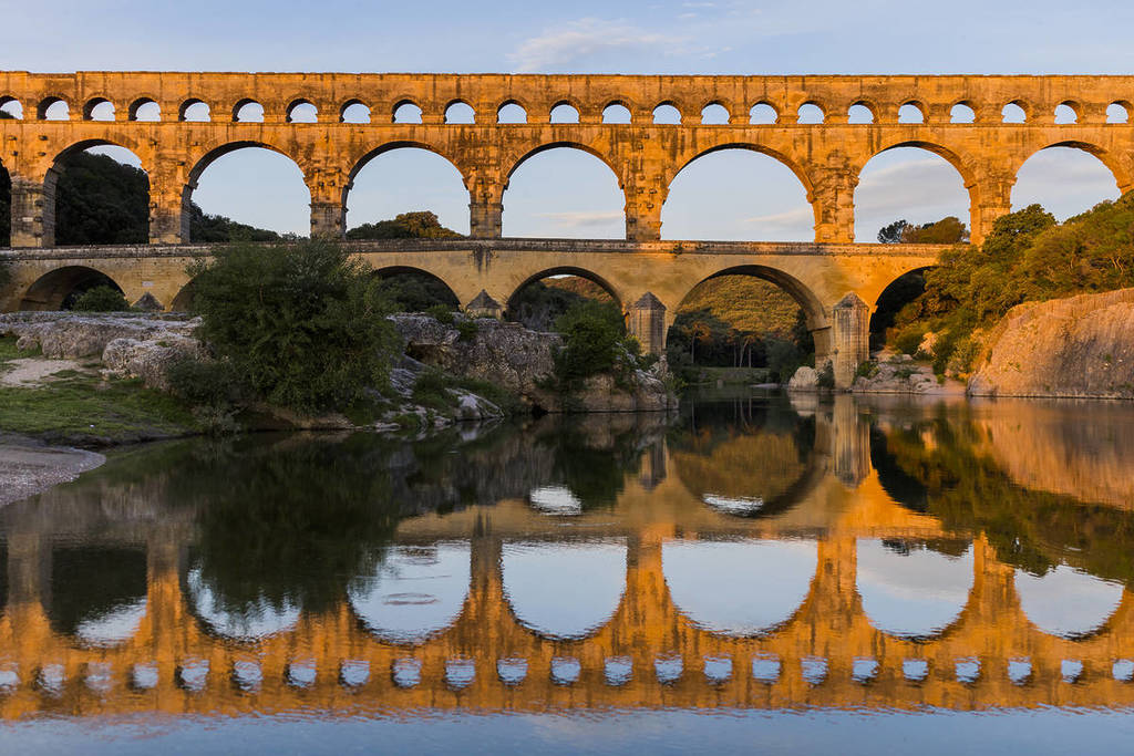 Photo du Pont du Gard en fin de journée qui se reflète dans l'eau