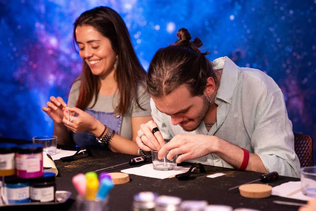 amici che ridono mentre preparano candele al Melting Galaxy Lab