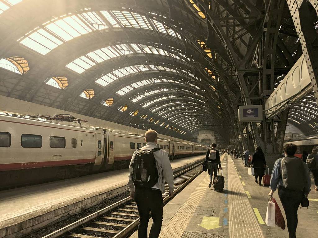 Gente caminando hacia el tren en la estación central de Milán