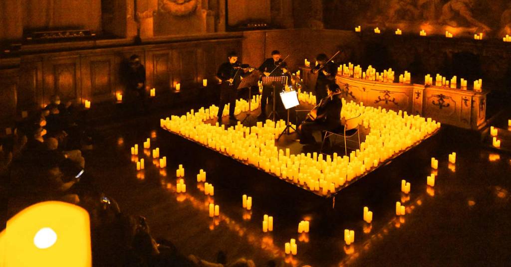 ein Streichquartett spielt, umgeben von Tausenden von Kerzen