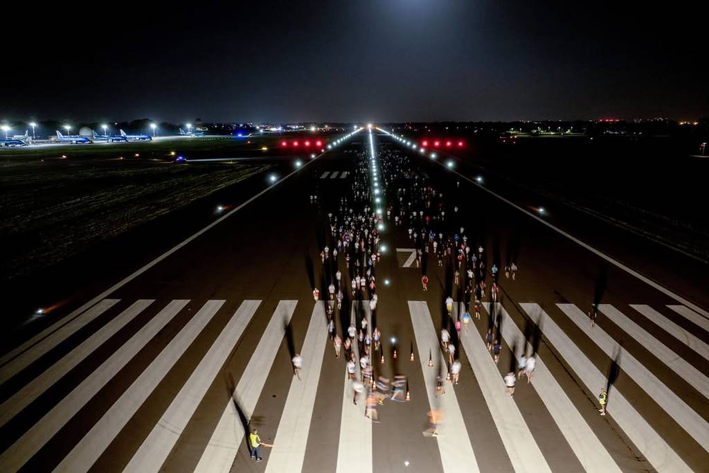 Partecipanti della corsa Milano Linate Runway si ritrovano sulla pista di decollo prima della partenza