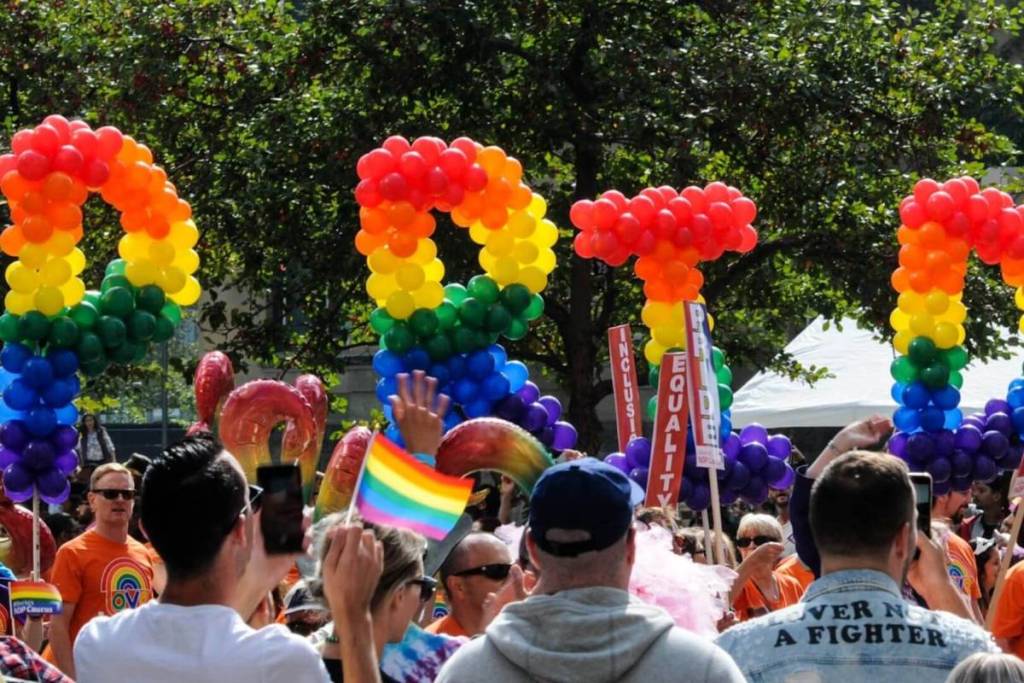 Persone che sfilano con palloncini e bandire arcobaleno