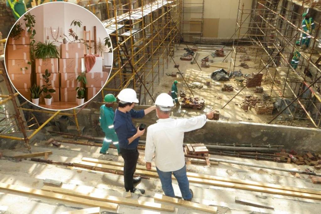 A renovation construction site with engineers in the foreground and, in a inset, moving boxes lined up in a room.