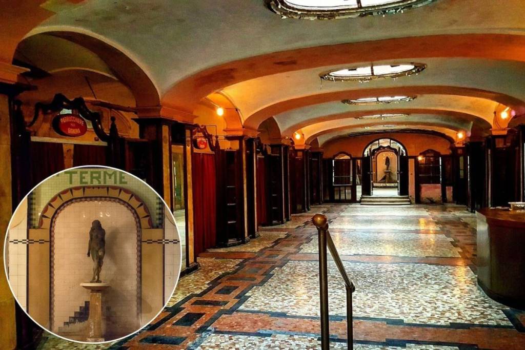 Interni in stile Art Déco dell'Albergo Diurno Venezia a Milano con la fontana della statua d'Igea e insegne d'epoca come Parrucchiere e Terme.