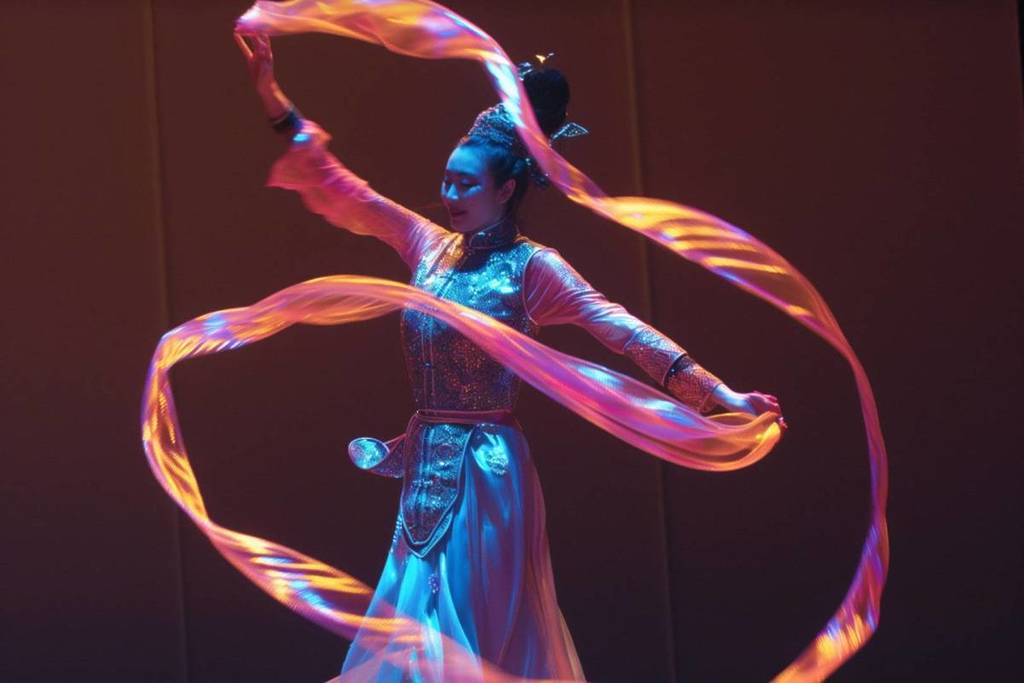 Photo of a circus artist in full number for Glow Circus