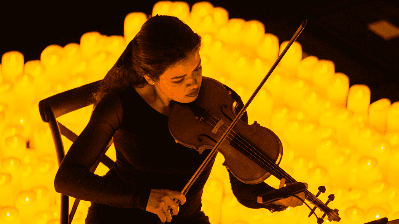 Photo d'un concert Candlelight et d'une violonniste en gros plan avec des bougies en fond