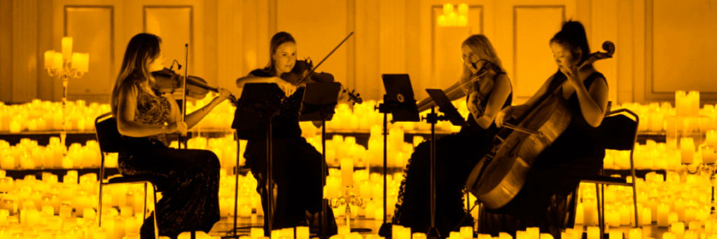 Photo de 4 musiciens formant un quatuor à cordes pour un concert Candlelight, entourés de bougies