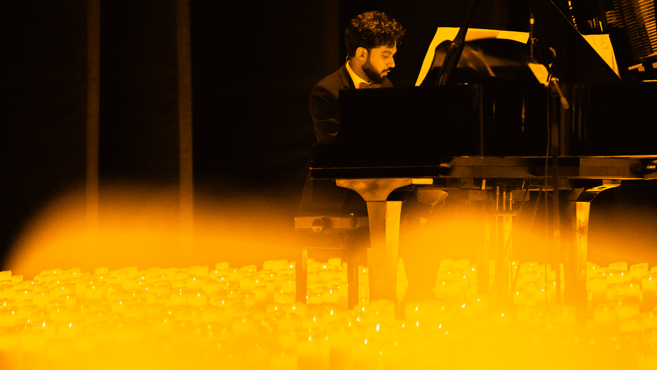 Photo d'un pianiste en train de jouer au milieu des bougies pour un concert Candlelight