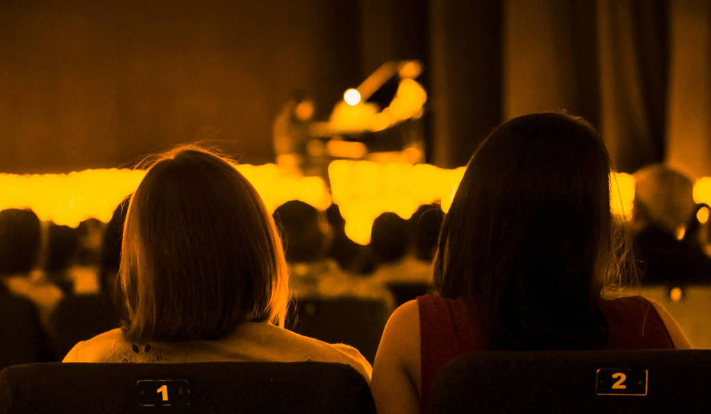 Foto von zwei Zuschauern von hinten bei einem Candlelight-Konzert
