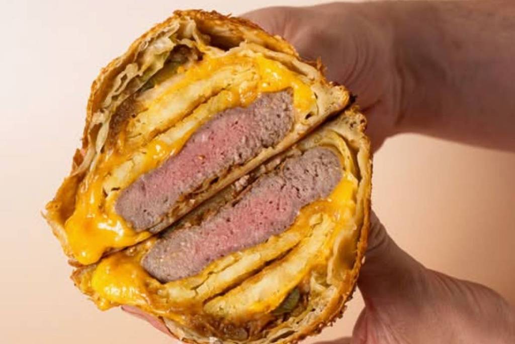 Ni comida rápida ni panadería clásica: Groot La Tourte envuelve una hamburguesa con queso fundido en una masa dorada por 17 € — y sirve un enorme pastel de flan para 3 personas por 15 €.