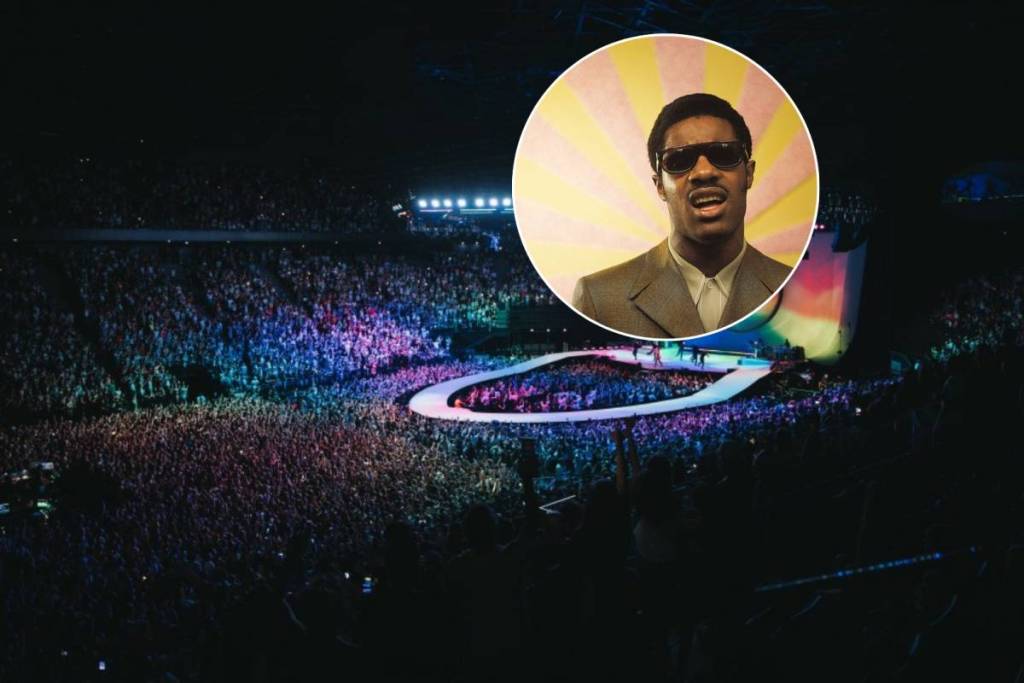 Stevie Wonder against the backdrop of a photo of the main hall at the Accor Arena in Paris