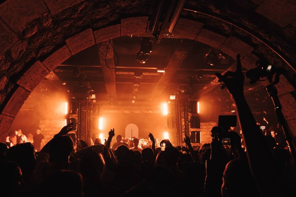 Foto vom Innenraum des Bridge Clubs unter orangefarbenen Neonröhren