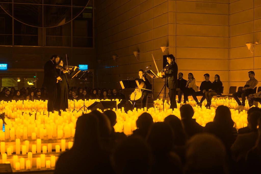 quarteto de cordas em um palco repleto de luzes de LED em um concerto Candlelight