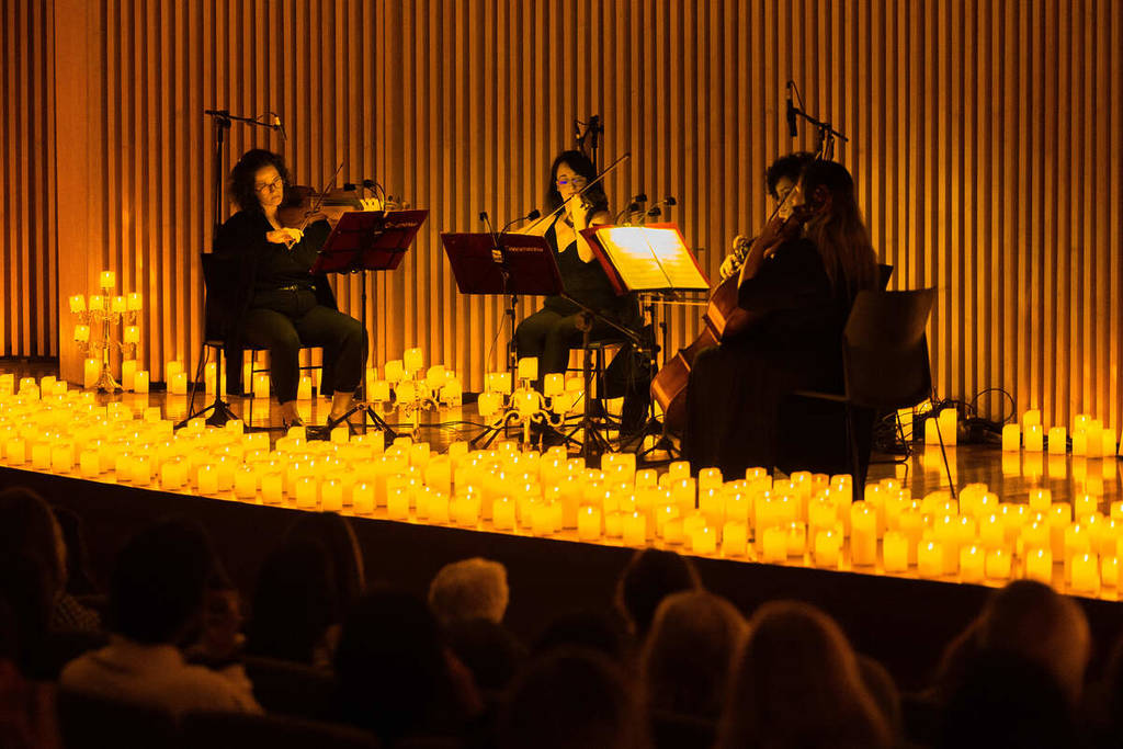 String quartet on a stage lit only by thousands of candles at the Candlelight Concert at the Museum of Tomorrow