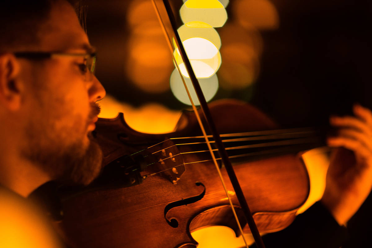 Primer plano de un músico tocando la viola durante un concierto Candlelight en Santiago.