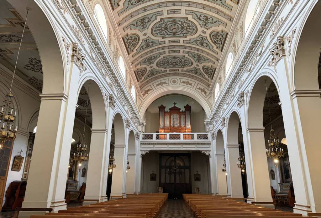 Vista del coro, órgano tubular y bancos de madera desde la nave de la Iglesia de San Ignacio en Santiago.