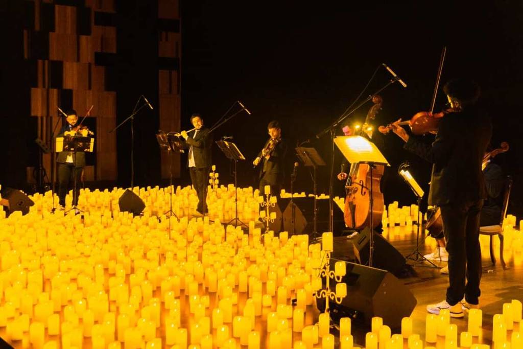 quarteto de cordas em um palco repleto de velas nos Concerto Candlelight no Teatro B32 em São Paulo