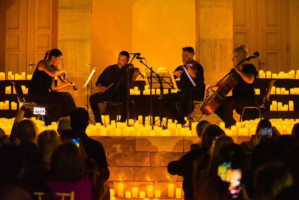 quarteto de cordas em um palco repleto de velas nos Concerto Candlelight no Teatro B32 em São Paulo