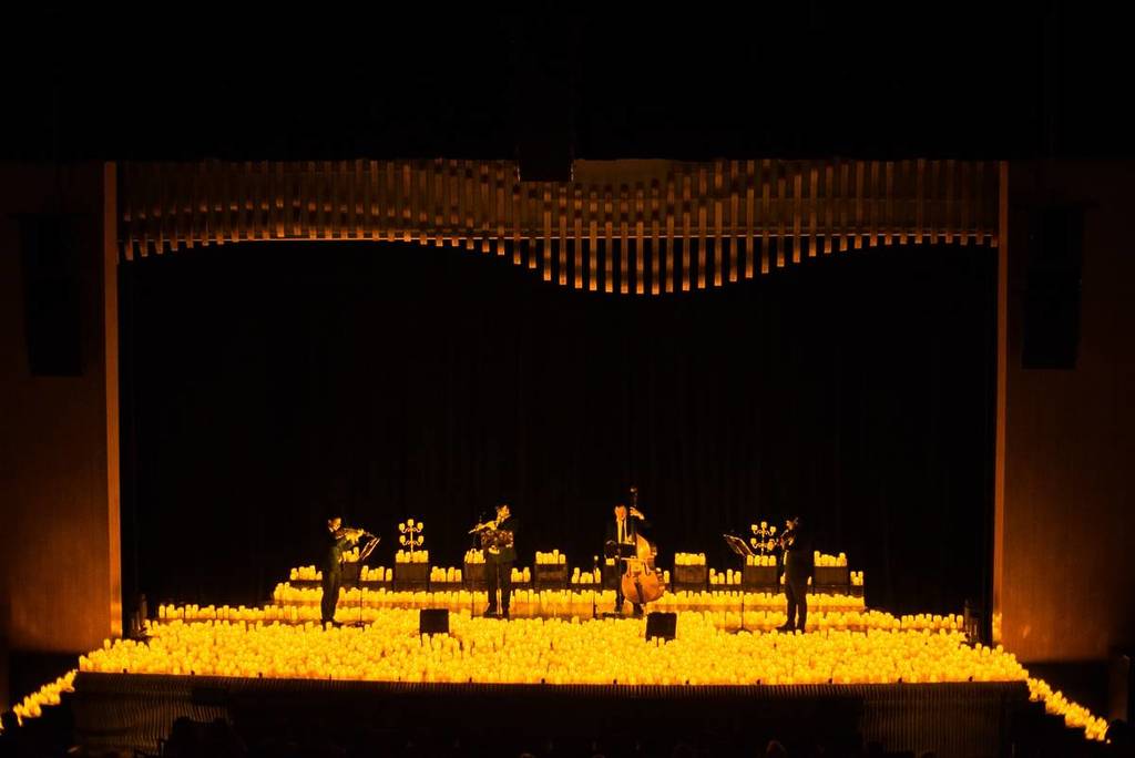 Cquarteto de cordas em um palco repleto de velas nos Concerto Candlelight no Teatro Villa Lobos em São Paulo