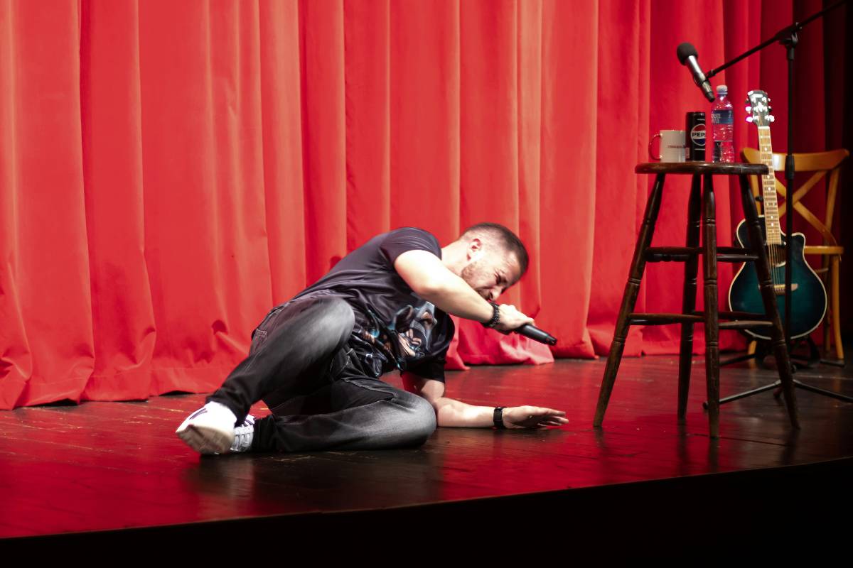 A comedian on stage falling over