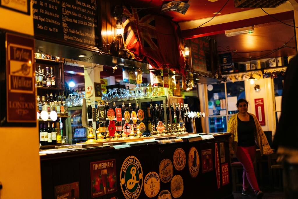 Moody lighting in a bar, a woman walking in