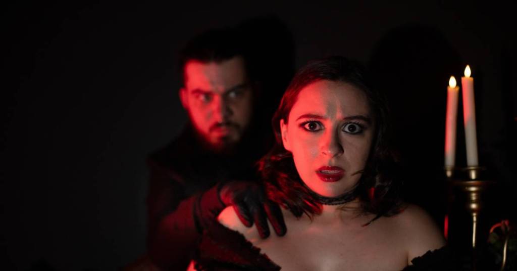 A man sneaking behind a woman to strangle her