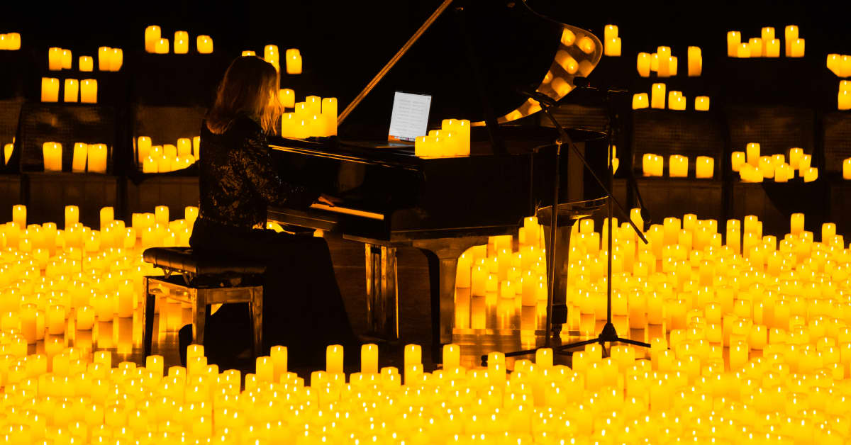 A pianist performing amid a sea of candles