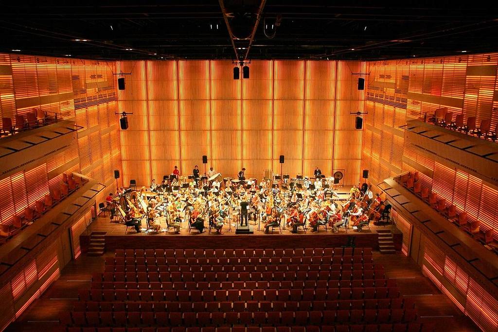 Las salas de conciertos del Muziekgebouw aan 't IJ con una orquesta tocando.