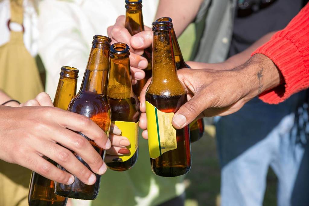 People toasting with glasses of beer in the sun