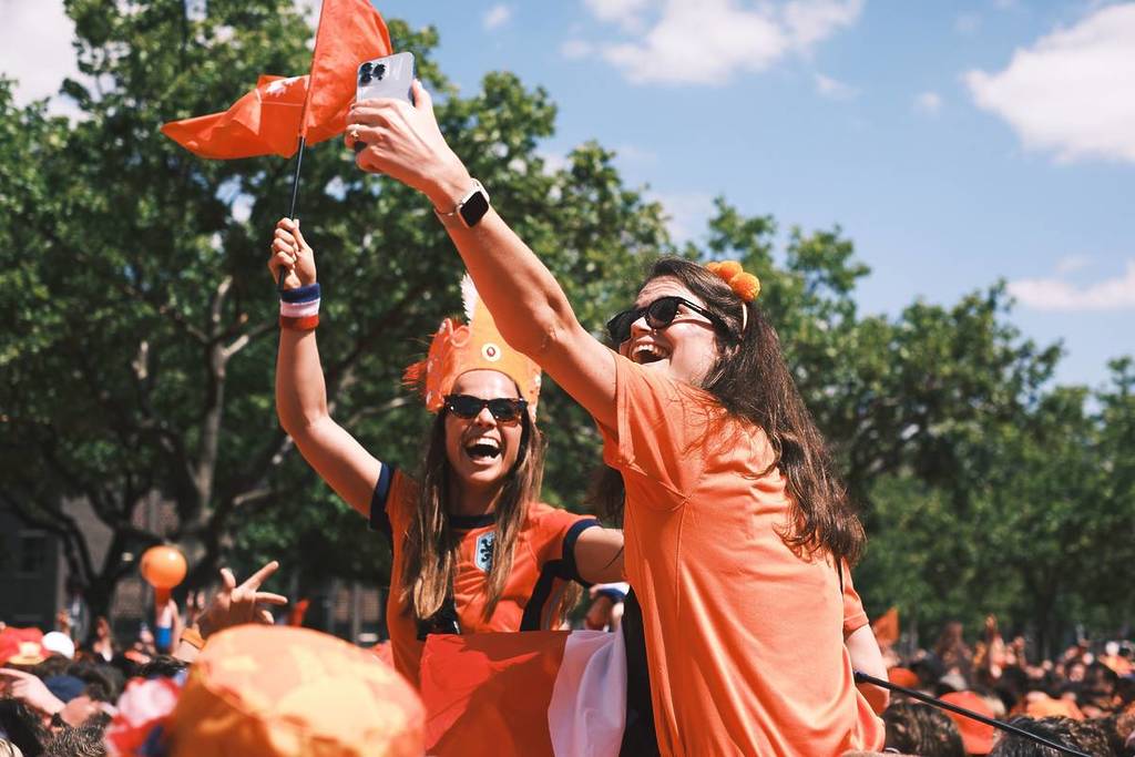 Due allegre tifose dell'Oranje con la maglia della Nazionale olandese si scattano un selfie con una bandiera durante i Mondiali di calcio.