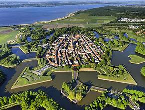 A soli 40 minuti da Amsterdam si trova una delle fortezze a stella del XVII secolo meglio conservate d’Europa, dichiarata patrimonio dell’UNESCO, completa di una doppia cerchia di canali e fortificazioni militari 